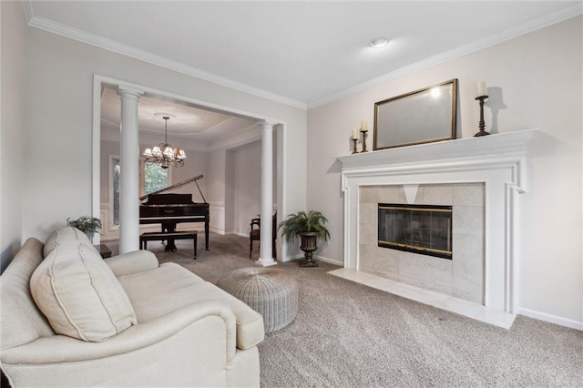 living room with carpet, a chandelier, ornamental molding, a tile fireplace, and ornate columns
