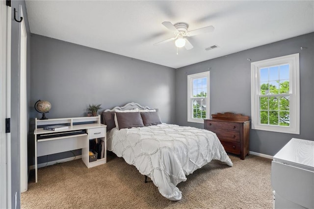 carpeted bedroom with a ceiling fan and baseboards