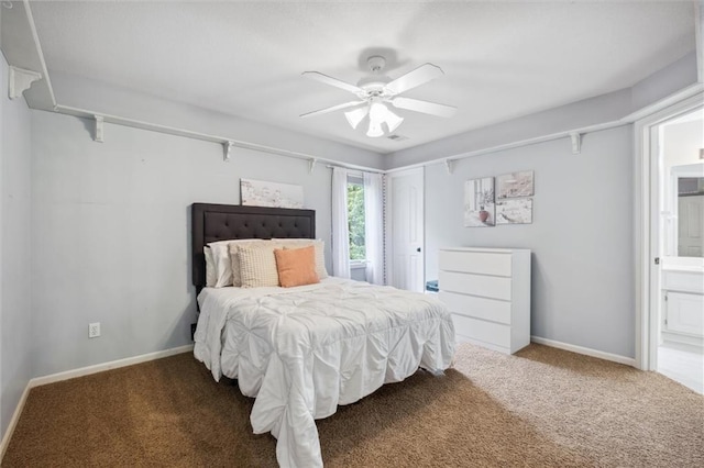 carpeted bedroom with baseboards, ensuite bath, and a ceiling fan