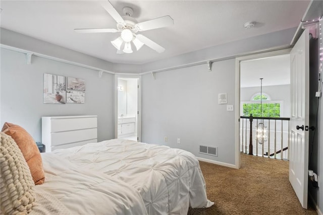 carpeted bedroom featuring ceiling fan, ensuite bathroom, and baseboards