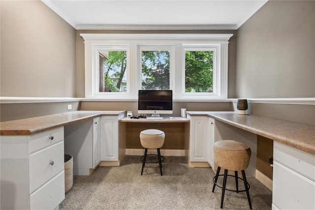 office space featuring crown molding, light carpet, and built in study area