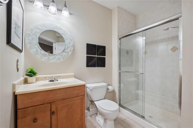 full bathroom featuring toilet, a stall shower, tile patterned floors, and vanity