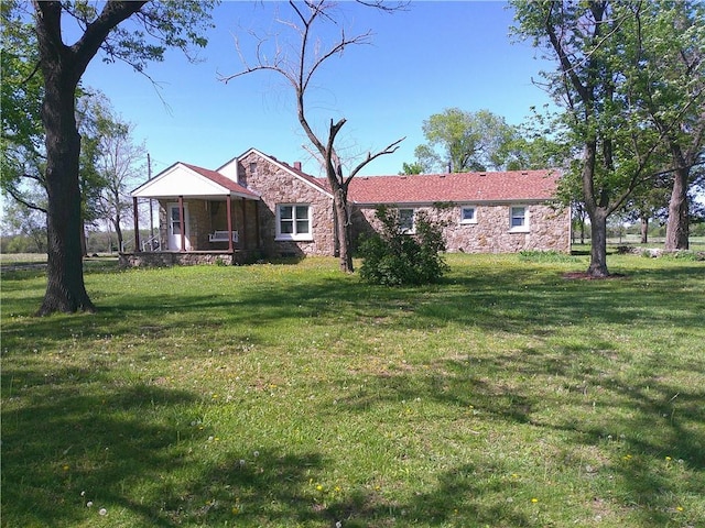 ranch-style house featuring stone siding and a front lawn