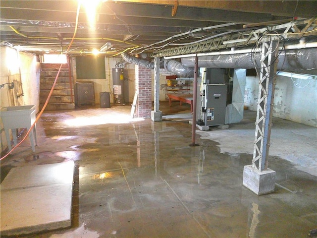 unfinished basement featuring a sink, heating unit, and electric water heater