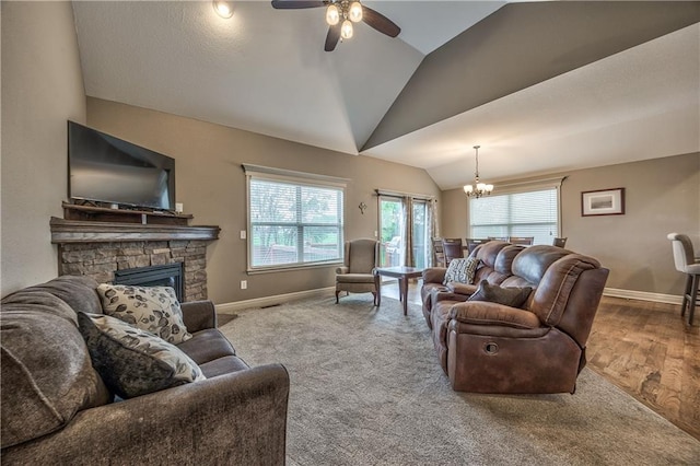 living room featuring baseboards, ceiling fan with notable chandelier, vaulted ceiling, and a fireplace