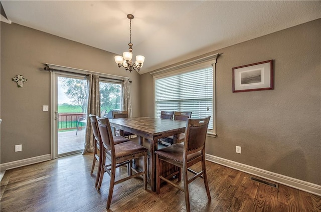 dining room with visible vents, dark wood-style flooring, baseboards, a chandelier, and vaulted ceiling