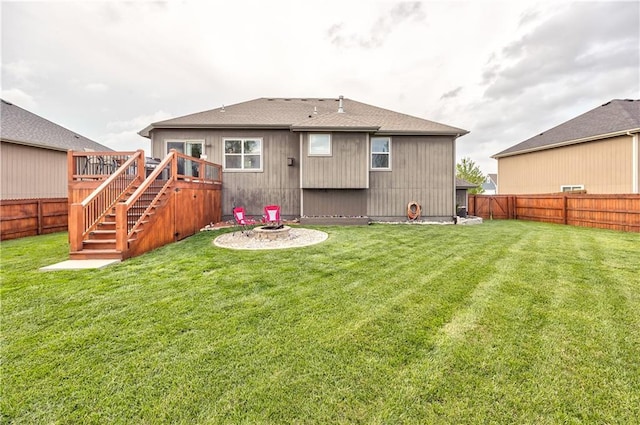 back of property with stairs, a fenced backyard, a fire pit, and a wooden deck