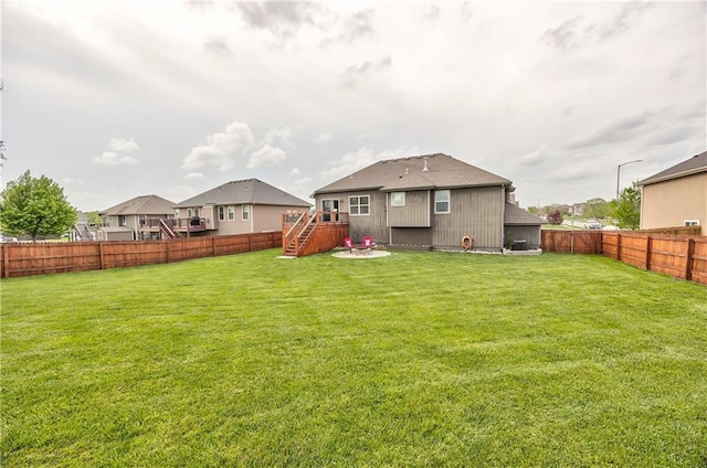 back of house featuring a fenced backyard and a yard