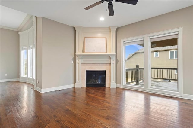 unfurnished living room with baseboards, visible vents, wood finished floors, and a ceiling fan