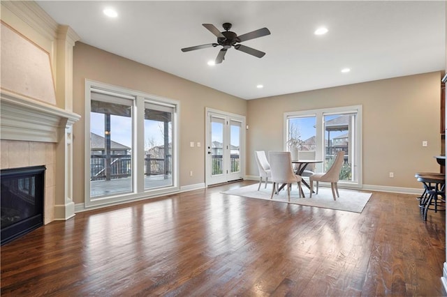 living area with recessed lighting, a tile fireplace, ceiling fan, baseboards, and wood finished floors