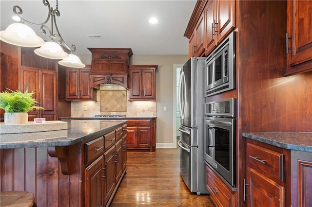 kitchen with appliances with stainless steel finishes, backsplash, baseboards, visible vents, and dark wood-style floors