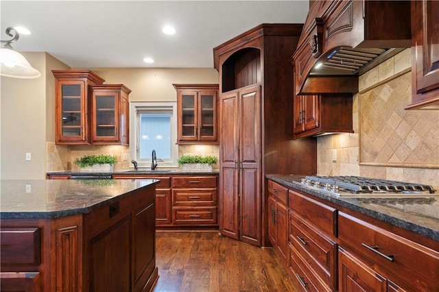 kitchen with dark wood-style floors, a sink, stainless steel gas cooktop, and tasteful backsplash