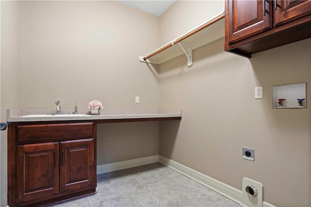 clothes washing area with hookup for an electric dryer, a sink, cabinet space, washer hookup, and baseboards