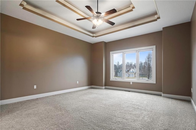 empty room featuring crown molding, ceiling fan, a raised ceiling, and carpet floors