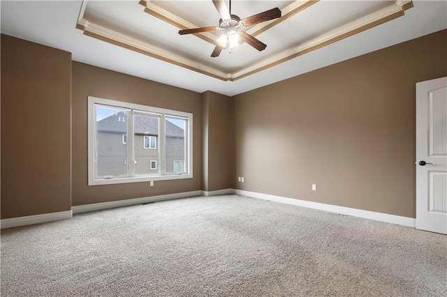 empty room featuring crown molding, baseboards, carpet, and a tray ceiling
