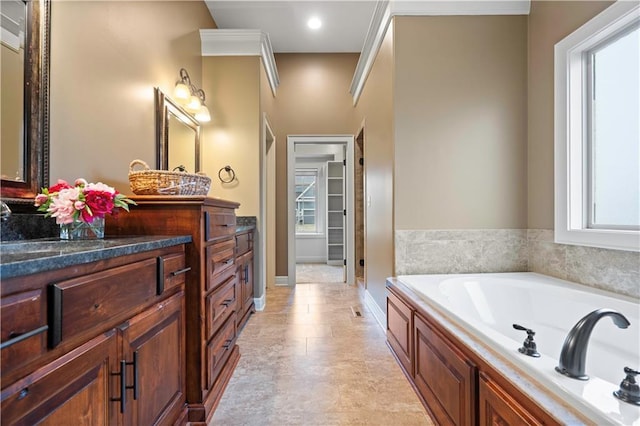 bathroom with a garden tub and vanity