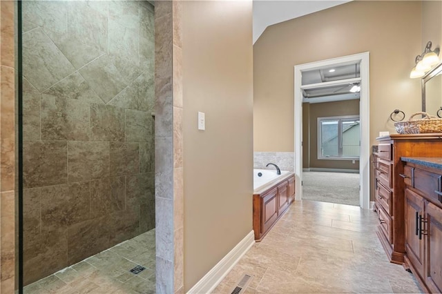 bathroom with visible vents, baseboards, walk in shower, a garden tub, and vanity