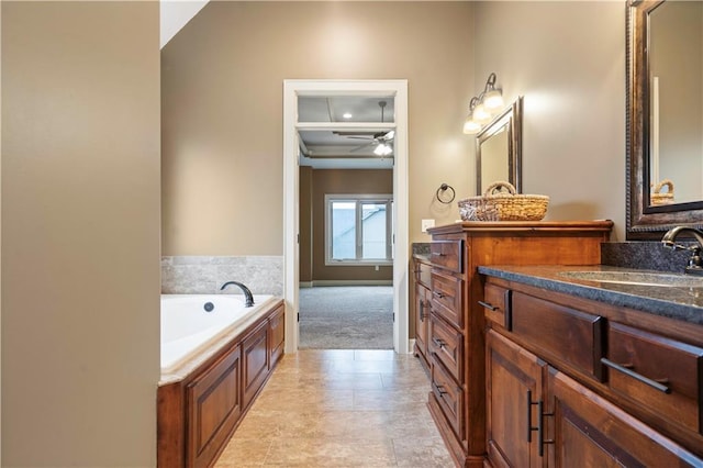 bathroom featuring ceiling fan, a garden tub, vanity, and baseboards
