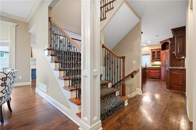 stairs with baseboards, visible vents, and wood finished floors