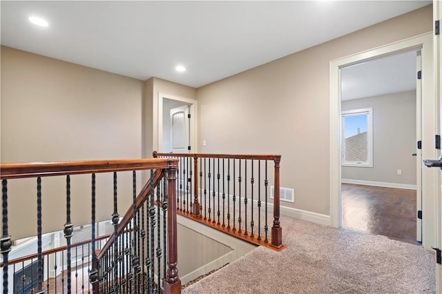 corridor featuring recessed lighting, an upstairs landing, visible vents, baseboards, and carpet floors