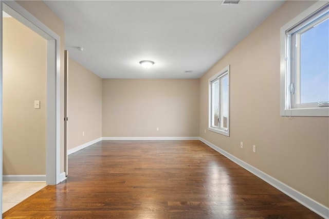 empty room with wood finished floors and baseboards