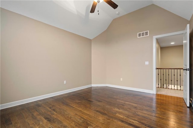 spare room featuring vaulted ceiling, ceiling fan, dark wood-style flooring, baseboards, and visible vents