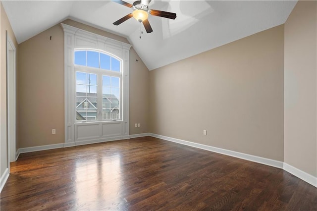 spare room featuring dark wood-style floors, baseboards, ceiling fan, and lofted ceiling