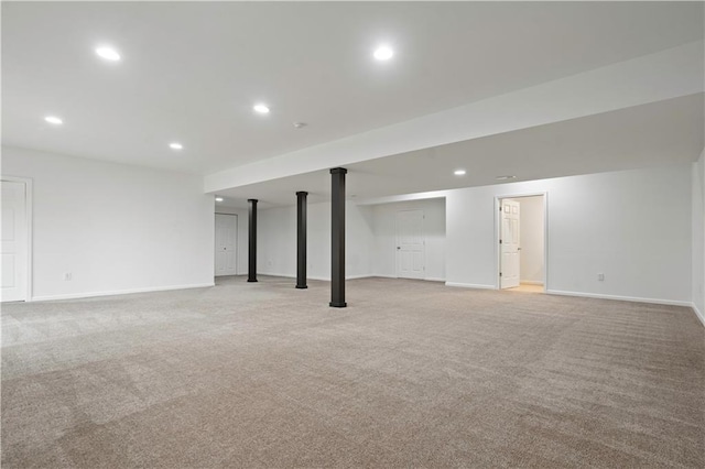 finished below grade area with baseboards, recessed lighting, and light colored carpet