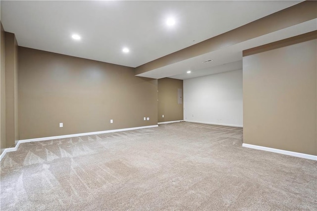 spare room with baseboards, recessed lighting, and light carpet