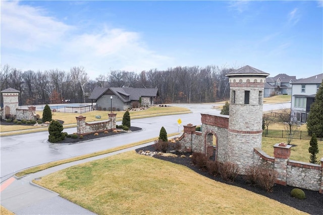 view of yard with curved driveway and fence