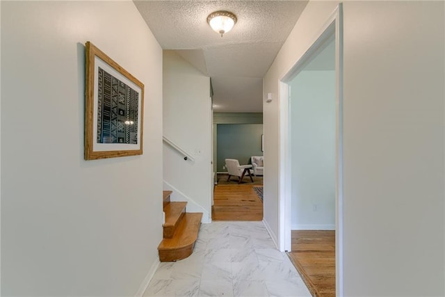4401 E 104th St, Kansas City, MO 64137 - corridor with a textured ceiling, stairway, light marble finish flooring, and baseboards