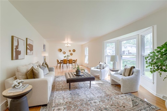4401 E 104th St, Kansas City, MO 64137 - living area with a chandelier, light wood-type flooring, and baseboards