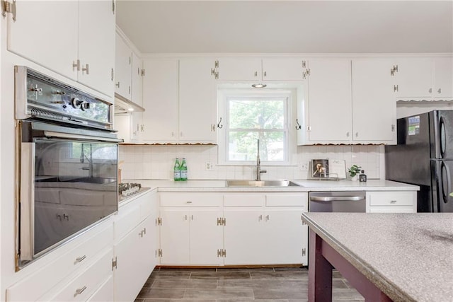4401 E 104th St, Kansas City, MO 64137 - kitchen with black appliances, a sink, light countertops, tasteful backsplash, and white cabinets