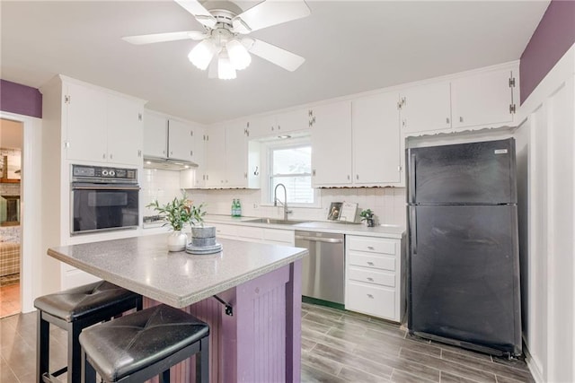 4401 E 104th St, Kansas City, MO 64137 - kitchen featuring black appliances, a sink, tasteful backsplash, and white cabinets