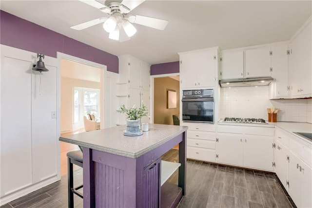 4401 E 104th St, Kansas City, MO 64137 - kitchen with black oven, white cabinetry, and light countertops
