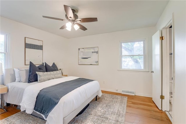 4401 E 104th St, Kansas City, MO 64137 - bedroom featuring multiple windows, light wood-style floors, baseboards, and a ceiling fan