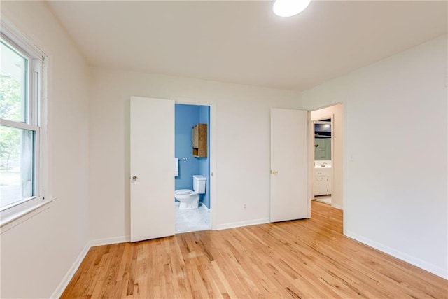 4401 E 104th St, Kansas City, MO 64137 - unfurnished bedroom featuring light wood finished floors, baseboards, and ensuite bathroom