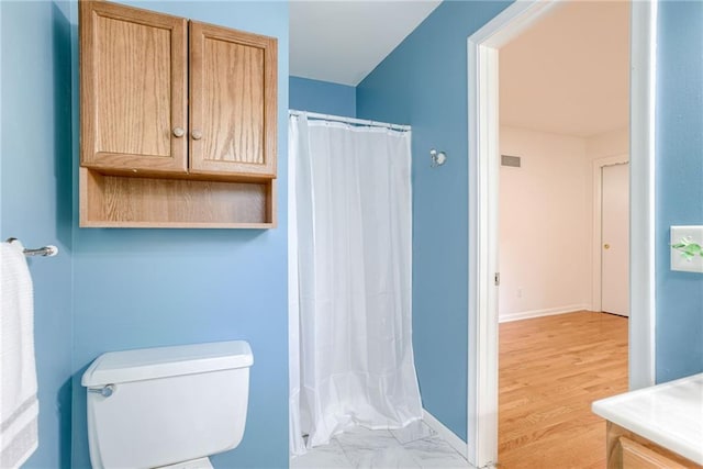 4401 E 104th St, Kansas City, MO 64137 - bathroom featuring toilet, vanity, curtained shower, baseboards, and wood finished floors