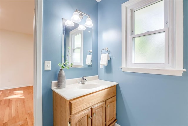 4401 E 104th St, Kansas City, MO 64137 - bathroom featuring healthy amount of natural light, vanity, wood finished floors, and baseboards
