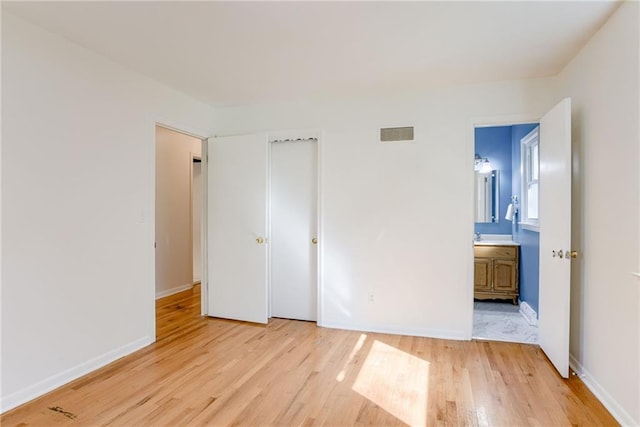 4401 E 104th St, Kansas City, MO 64137 - unfurnished bedroom featuring light wood-style floors, baseboards, and ensuite bathroom