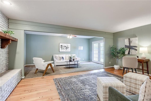 4401 E 104th St, Kansas City, MO 64137 - living room featuring light wood-type flooring, a ceiling fan, and baseboards