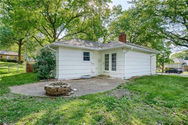 4401 E 104th St, Kansas City, MO 64137 - rear view of property with a chimney, a fire pit, and a patio