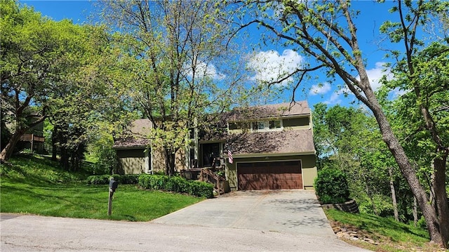view of front of house with an attached garage, stucco siding, driveway, and a front yard