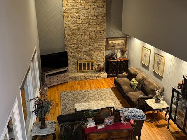 living area with a towering ceiling and wood finished floors