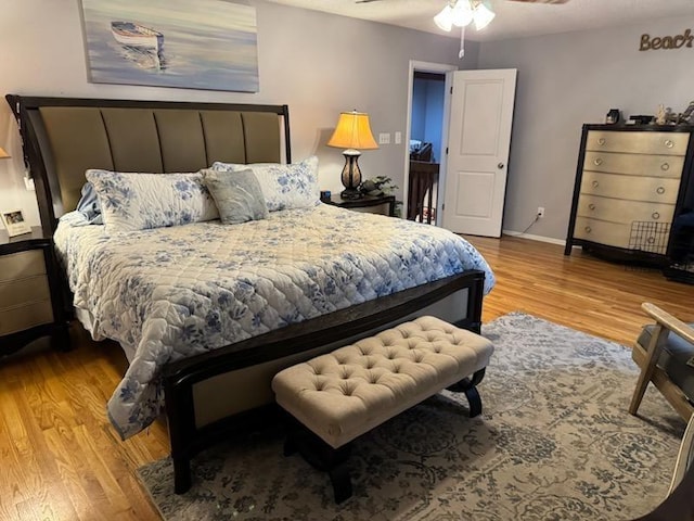 bedroom featuring baseboards, ceiling fan, and wood finished floors