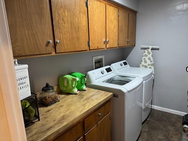 laundry area with baseboards, washer and dryer, and cabinet space