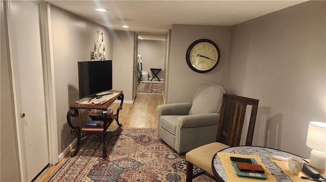 living area with light wood-style flooring, baseboards, and recessed lighting