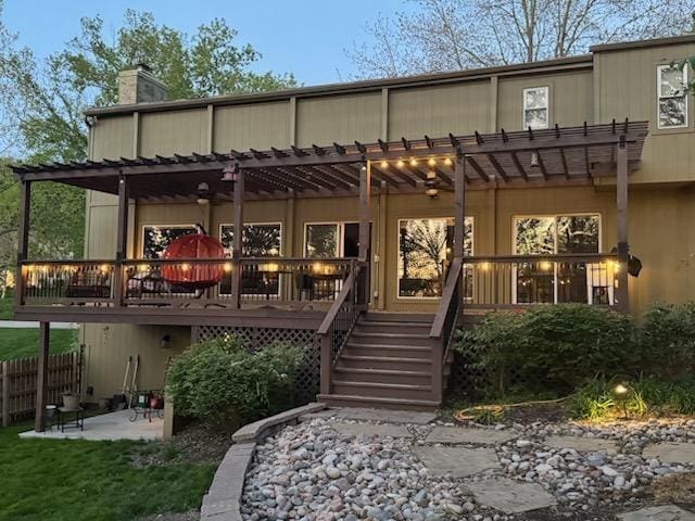 rear view of house featuring fence, stairs, a patio, a pergola, and a chimney