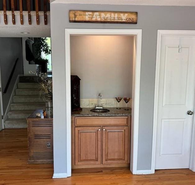 16036 Meadow Ln, Stilwell, KS 66085 - bar featuring a sink, light wood finished floors, stairs, and indoor wet bar