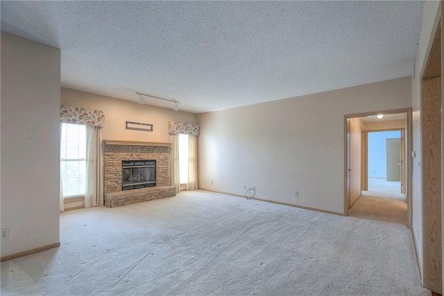 17800 E Bolger Rd Unit 245-A, Independence, MO 64055 - unfurnished living room with carpet flooring, a textured ceiling, a fireplace, and baseboards